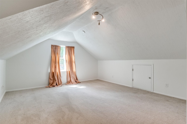 3301 Regent Dr, Plano, TX 75075 - additional living space with carpet, vaulted ceiling, baseboards, and a textured ceiling