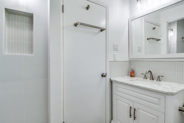 3301 Regent Dr, Plano, TX 75075 - bathroom with vanity, backsplash, and tile walls