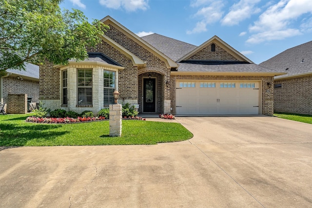 5524 Hollytree, Tyler, TX 75703 - french country style house featuring brick siding, concrete driveway, a garage, a front yard, and roof with shingles