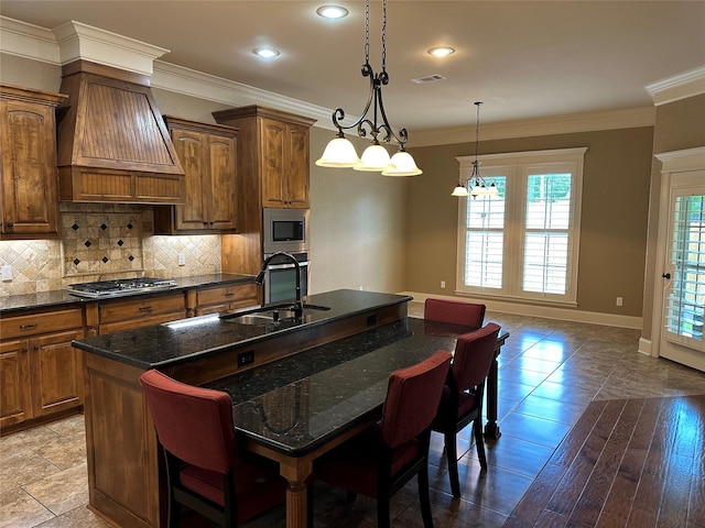 5524 Hollytree, Tyler, TX 75703 - kitchen with a sink, appliances with stainless steel finishes, a center island with sink, a breakfast bar, and tasteful backsplash