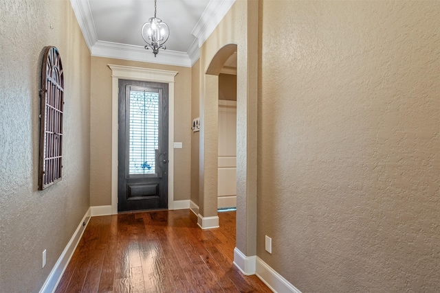 5524 Hollytree, Tyler, TX 75703 - foyer entrance with a textured wall, arched walkways, dark wood finished floors, crown molding, and a chandelier
