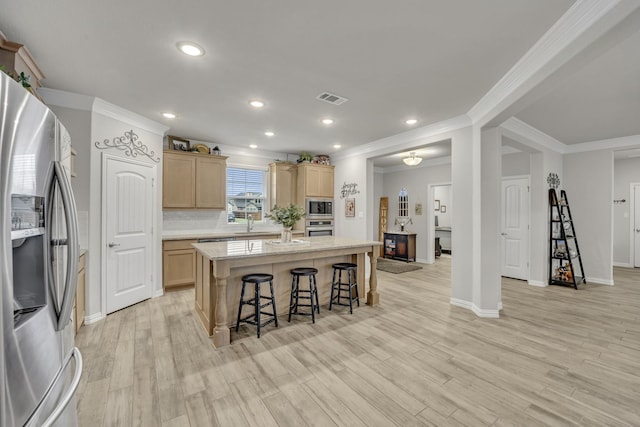 208 Beechcraft Ct, Caddo Mills, TX 75135 - kitchen with stainless steel appliances, light brown cabinetry, a breakfast bar area, a kitchen island, and light wood-style flooring