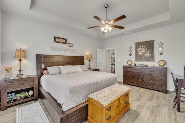 208 Beechcraft Ct, Caddo Mills, TX 75135 - bedroom with a tray ceiling, light wood-type flooring, baseboards, and a ceiling fan