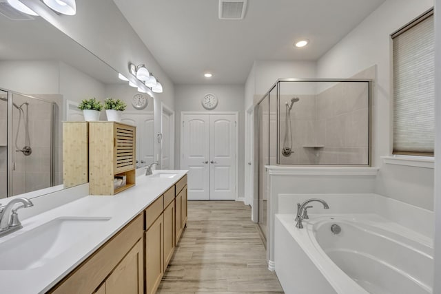 208 Beechcraft Ct, Caddo Mills, TX 75135 - full bathroom featuring a stall shower, a bath, double vanity, wood finished floors, and recessed lighting