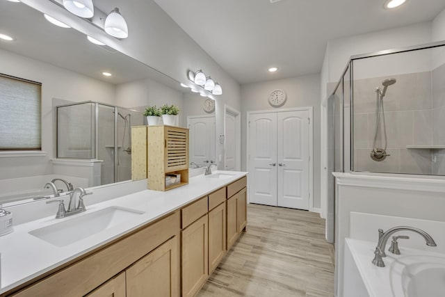 208 Beechcraft Ct, Caddo Mills, TX 75135 - full bathroom with a shower stall, double vanity, a garden tub, recessed lighting, and wood finished floors