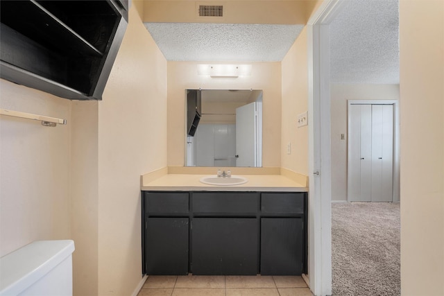 1226 Baylor Ave Unit 116, Waco, TX 76706 - bathroom featuring a textured ceiling, toilet, vanity, baseboards, and tile patterned floors