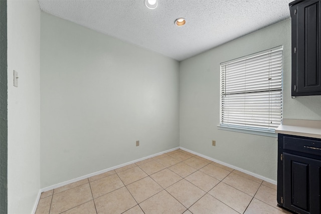 1226 Baylor Ave Unit 116, Waco, TX 76706 - unfurnished dining area featuring a textured ceiling, light tile patterned floors, and baseboards