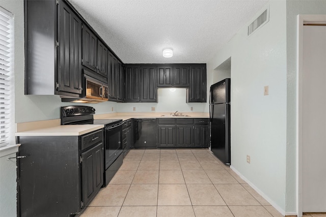 1226 Baylor Ave Unit 116, Waco, TX 76706 - kitchen with black appliances, a sink, a textured ceiling, light tile patterned floors, and light countertops