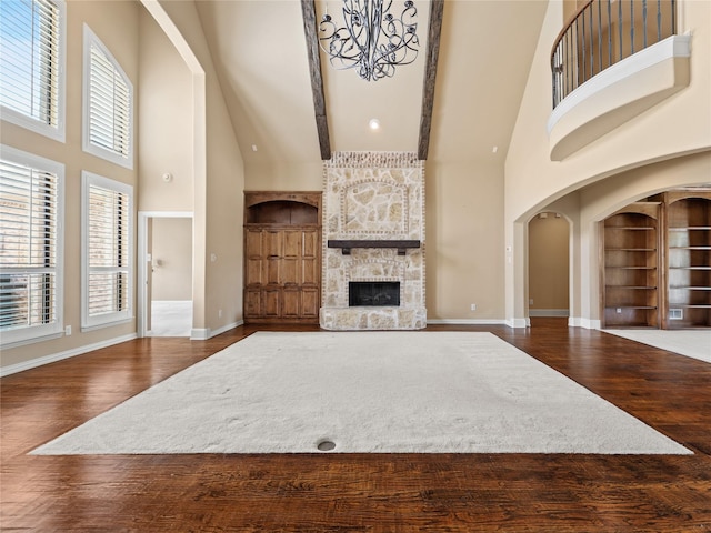 1413 Prairie Dr, Carrollton, TX 75007 - unfurnished living room featuring a towering ceiling, built in shelves, wood finished floors, a fireplace, and baseboards