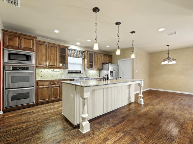 1413 Prairie Dr, Carrollton, TX 75007 - kitchen with stainless steel appliances, an island with sink, dark wood-style flooring, a breakfast bar, and recessed lighting