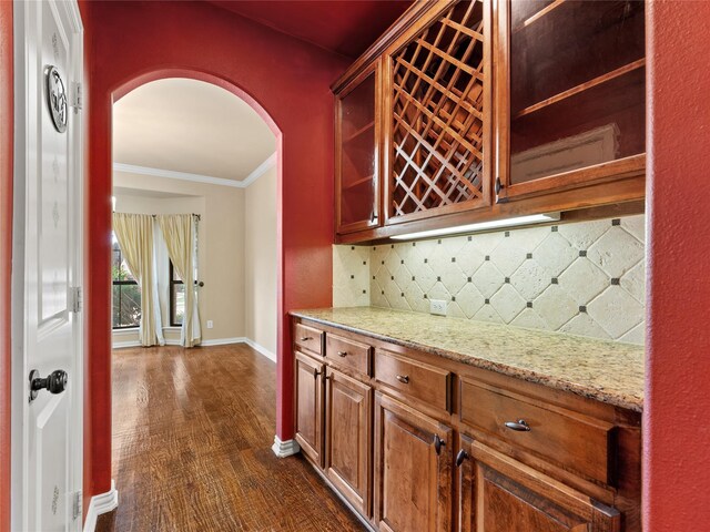 1413 Prairie Dr, Carrollton, TX 75007 - indoor dry bar with arched walkways, ornamental molding, backsplash, baseboards, and dark wood-style flooring