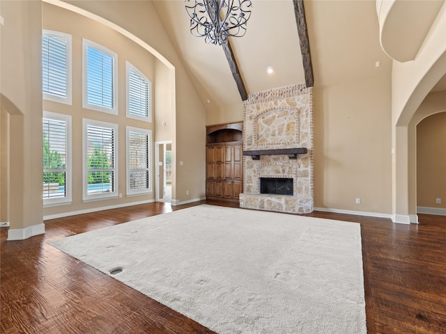 1413 Prairie Dr, Carrollton, TX 75007 - unfurnished living room with high vaulted ceiling, a fireplace, wood finished floors, arched walkways, and baseboards