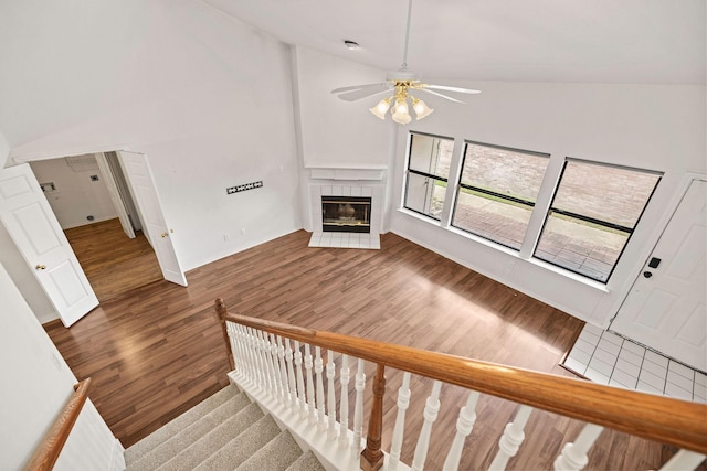 1120 Forest Creek St, Benbrook, TX 76126 - unfurnished living room featuring wood finished floors, a ceiling fan, a tile fireplace, stairway, and high vaulted ceiling