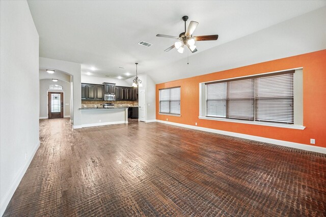 5013 Spruce, Krum, TX 76249 - unfurnished living room featuring ceiling fan, vaulted ceiling, arched walkways, and baseboards
