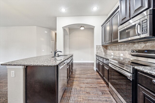 5013 Spruce, Krum, TX 76249 - kitchen featuring stainless steel appliances, a sink, arched walkways, light stone countertops, and recessed lighting