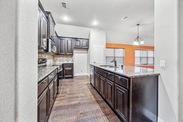 5013 Spruce, Krum, TX 76249 - kitchen with stainless steel appliances, a sink, dark brown cabinets, backsplash, and light stone countertops