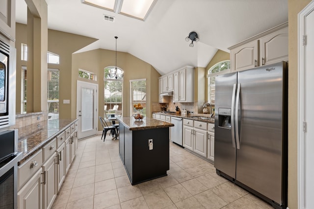 1820 Lacey Oak Ln, Keller, TX 76248 - kitchen with appliances with stainless steel finishes, tasteful backsplash, a center island, a sink, and lofted ceiling