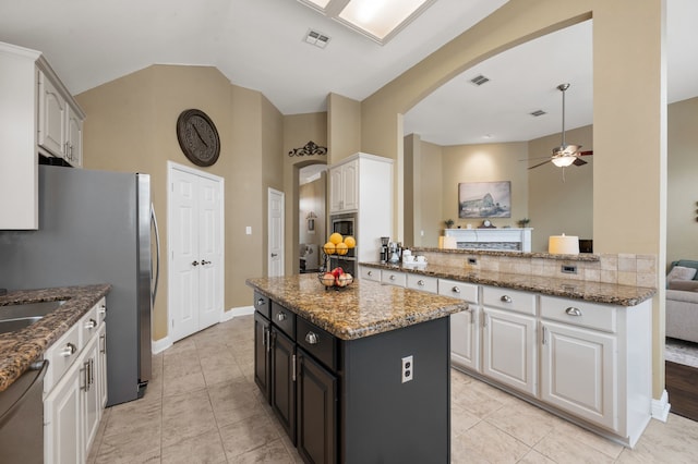 1820 Lacey Oak Ln, Keller, TX 76248 - kitchen featuring arched walkways, stainless steel appliances, ceiling fan, a kitchen island, and white cabinets
