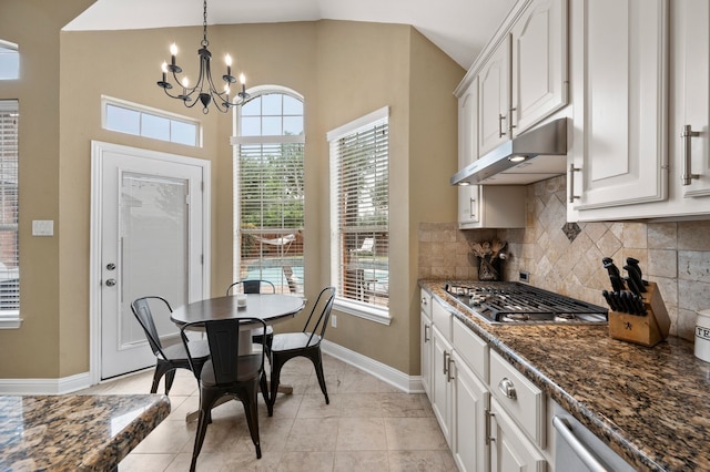 1820 Lacey Oak Ln, Keller, TX 76248 - kitchen with under cabinet range hood, baseboards, a chandelier, tasteful backsplash, and white cabinetry