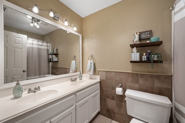 1820 Lacey Oak Ln, Keller, TX 76248 - bathroom with toilet, tile walls, double vanity, tile patterned floors, and a wainscoted wall