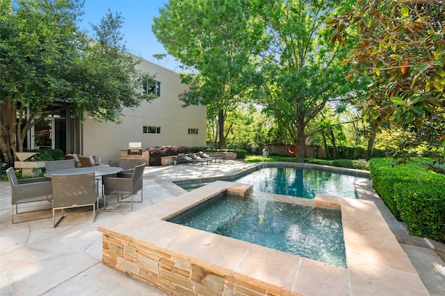 view of pool with a patio, fence, a pool with connected hot tub, and outdoor dining area