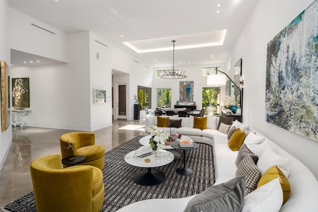 living area featuring a high ceiling, a chandelier, concrete flooring, recessed lighting, and baseboards