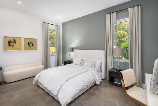 bedroom with concrete flooring and recessed lighting