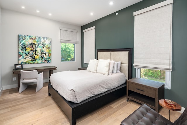 bedroom with multiple windows, wood finished floors, recessed lighting, and baseboards