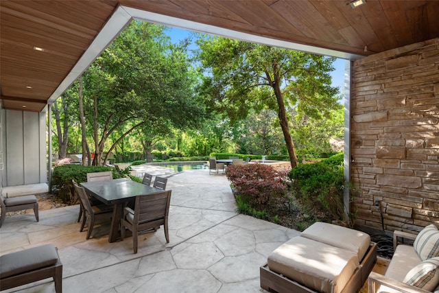 view of patio / terrace featuring outdoor dining space and an outdoor pool