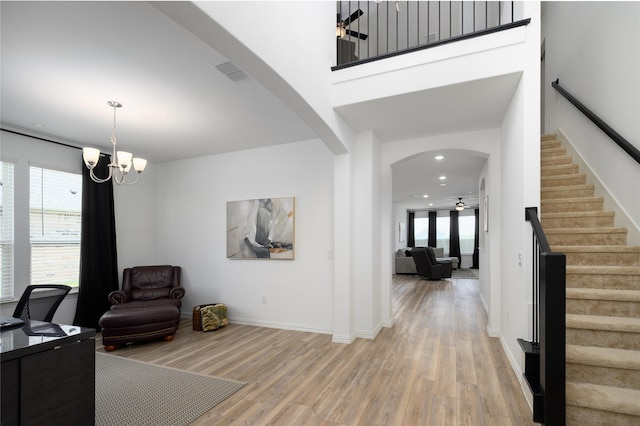 foyer entrance with stairs, plenty of natural light, light wood finished floors, arched walkways, and recessed lighting