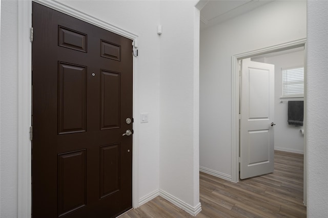 foyer entrance with wood finished floors and baseboards