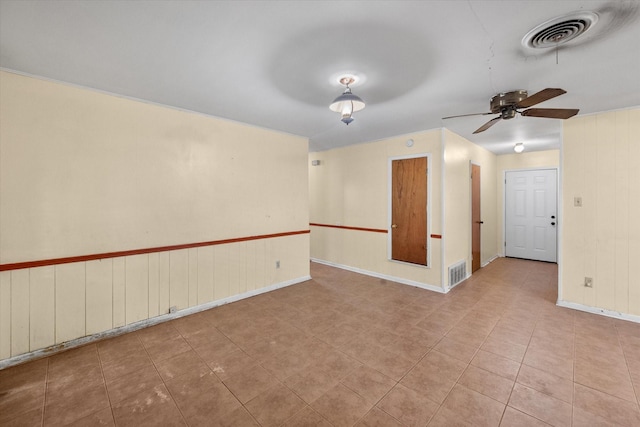 tiled spare room featuring a ceiling fan and baseboards