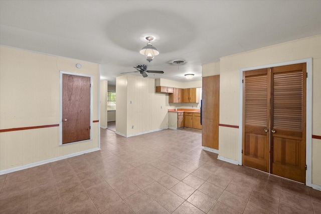 unfurnished living room featuring ceiling fan, baseboards, and light tile patterned floors