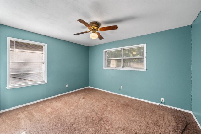 spare room featuring carpet, a ceiling fan, and baseboards