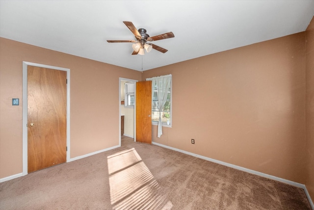 unfurnished bedroom featuring baseboards, carpet flooring, and a ceiling fan