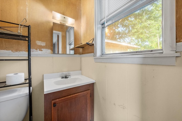 half bath featuring vanity and toilet
