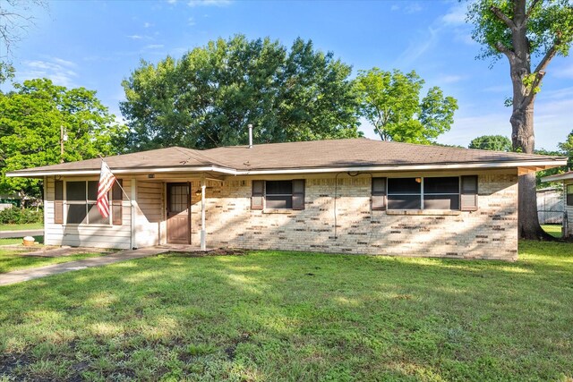 ranch-style home featuring a front lawn and brick siding