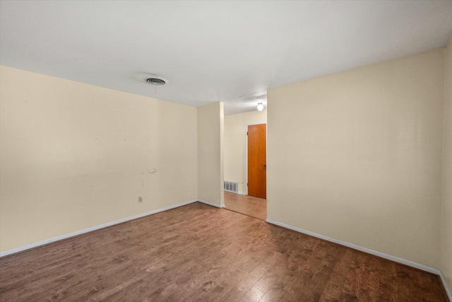 empty room featuring wood finished floors and baseboards