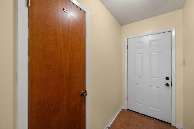 doorway featuring baseboards and tile patterned flooring