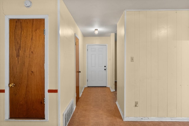 hallway featuring tile patterned floors and baseboards