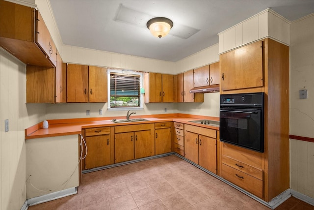 kitchen with black appliances, a sink, brown cabinets, and light countertops