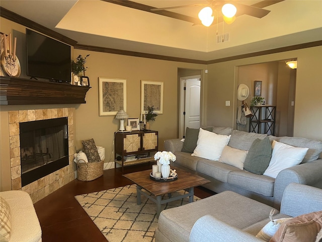 living area featuring a ceiling fan, light wood finished floors, and a fireplace