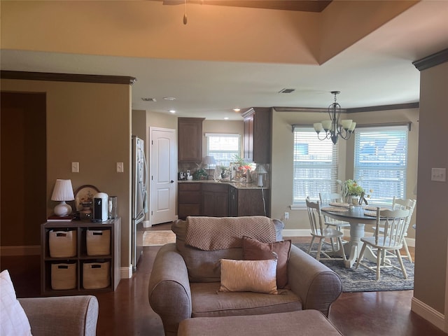living area featuring a chandelier, baseboards, and recessed lighting
