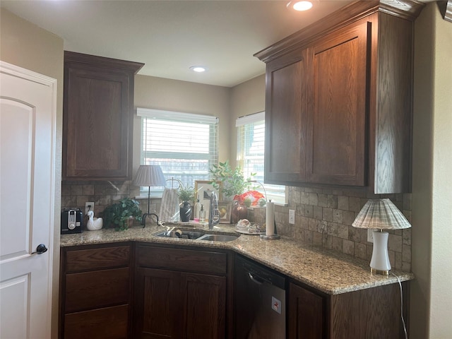 kitchen featuring stainless steel dishwasher, a sink, decorative backsplash, plenty of natural light, and recessed lighting