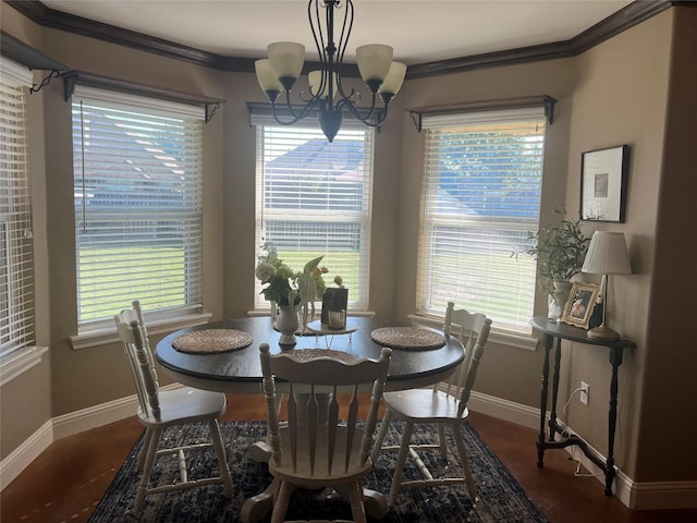 dining room with baseboards, a chandelier, ornamental molding, plenty of natural light, and wood finished floors