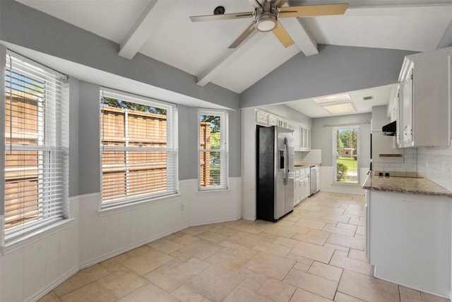 kitchen with stainless steel fridge, white cabinetry, wainscoting, a ceiling fan, and decorative backsplash