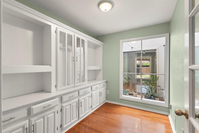 interior space with light wood finished floors and baseboards