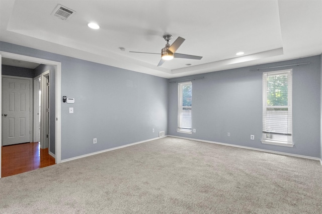 carpeted spare room with a tray ceiling, baseboards, a ceiling fan, and recessed lighting
