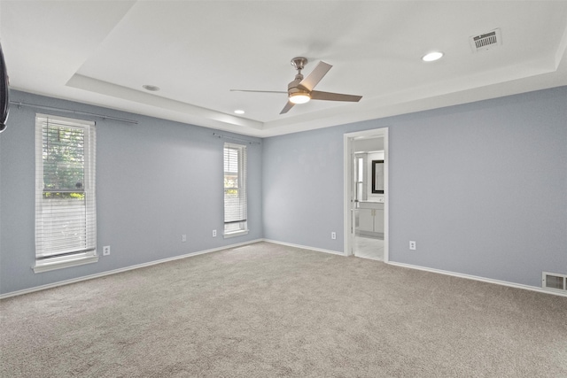 carpeted empty room with a tray ceiling, a ceiling fan, baseboards, and recessed lighting