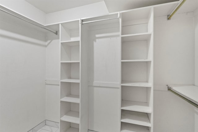 spacious closet with marble look tile flooring